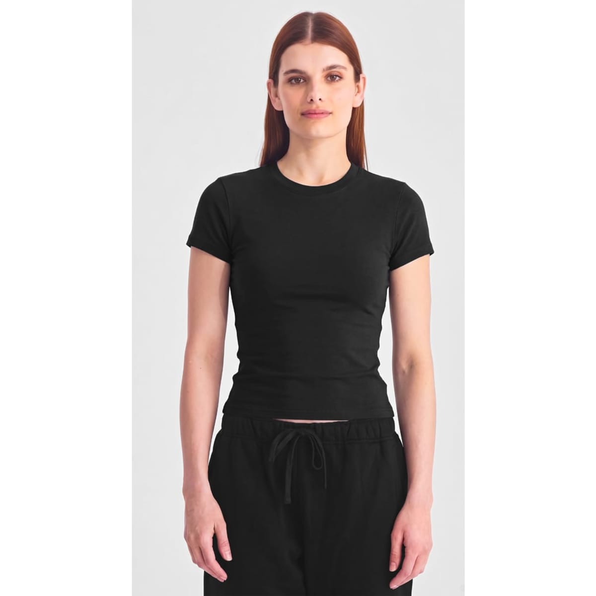 A women's black baby tee with short sleeves, fitted design, and a logo on the front.