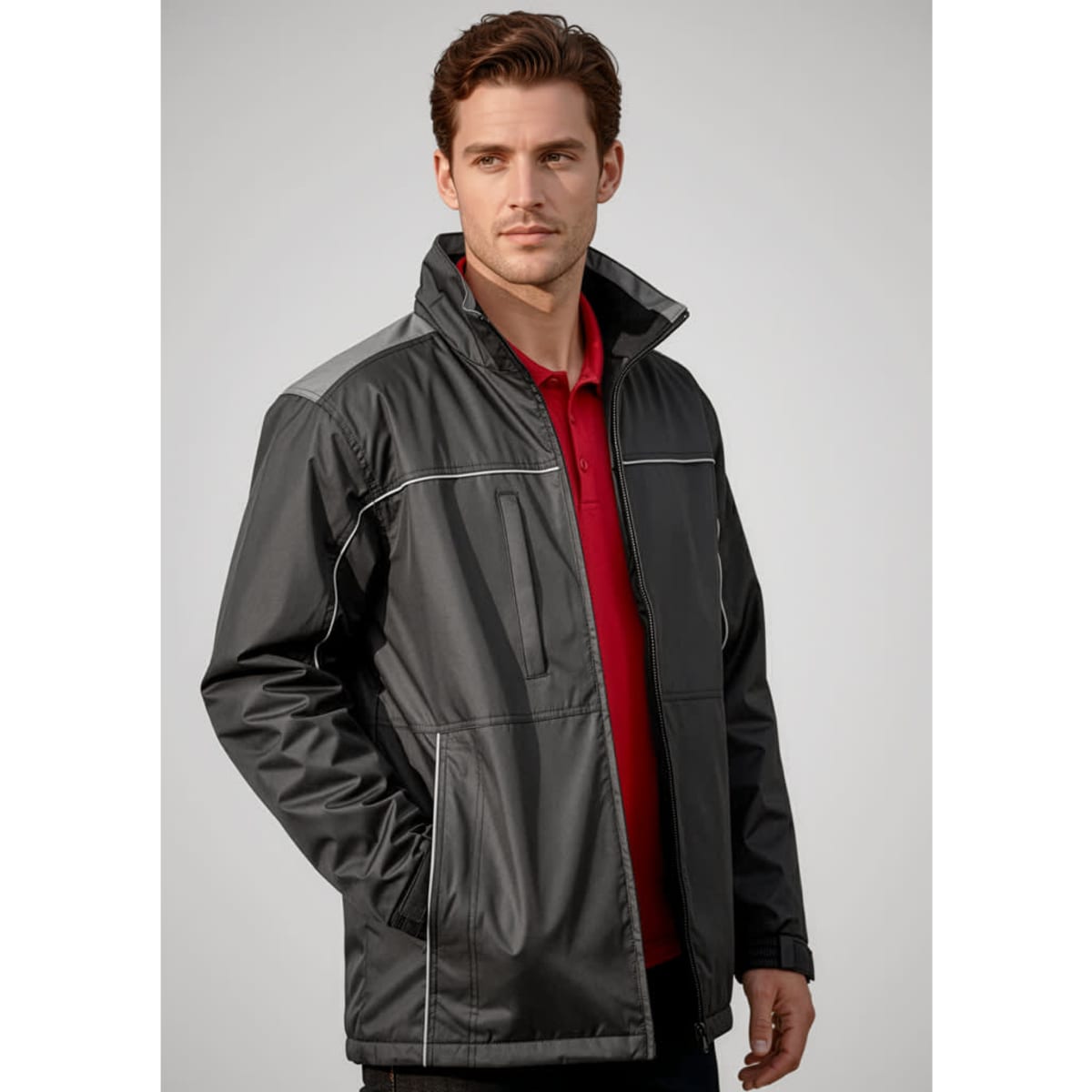 A man models a black unisex reactor jacket with grey accents, featuring zip pockets and a collar.