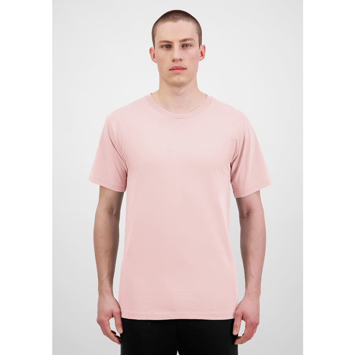 A plain pink short sleeve tee is displayed on a model against a neutral background. The shirt features a logo.