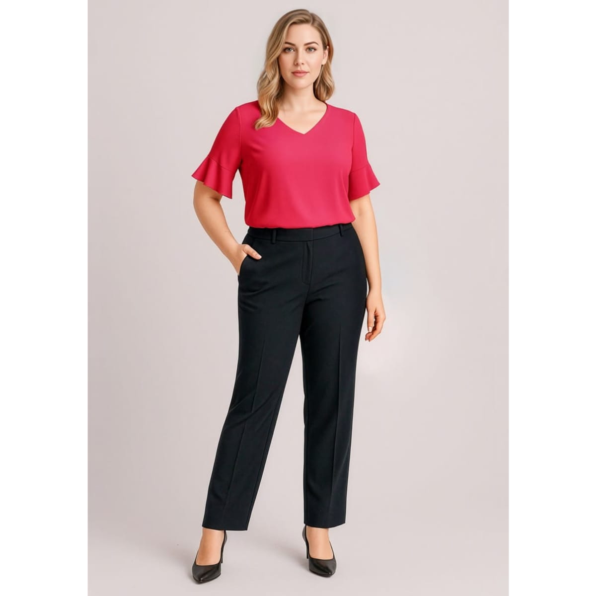 A woman wearing a pink top and black adjustable waist pants stands with one hand in her pocket. The pants have a sleek design.