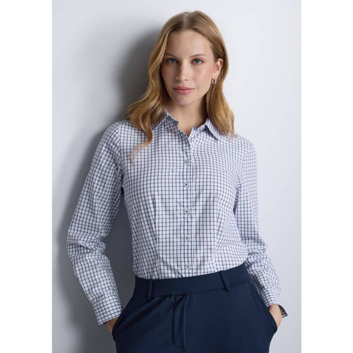 A long sleeve women's shirt in navy and white check pattern, featuring a collar and button-down front.