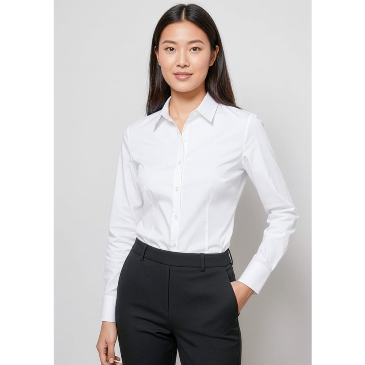 A white long sleeve button-up shirt styled with a classic collar, paired with black trousers. The shirt features branding.