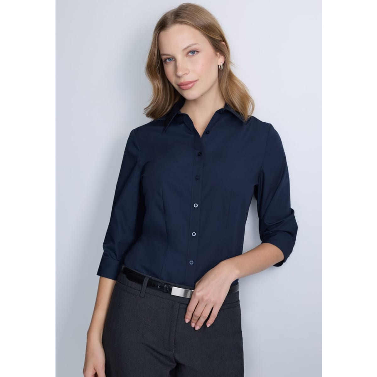 A navy blue women's 3/4 sleeve shirt, featuring a collared neckline and button front, worn by a model.
