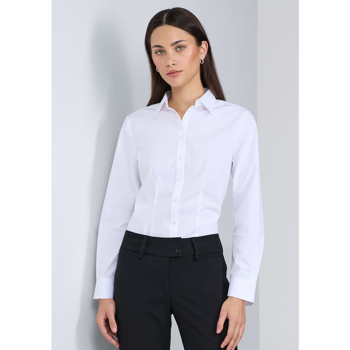 A white long sleeve shirt with a collared neck, displayed on a model wearing black pants. Features a logo.