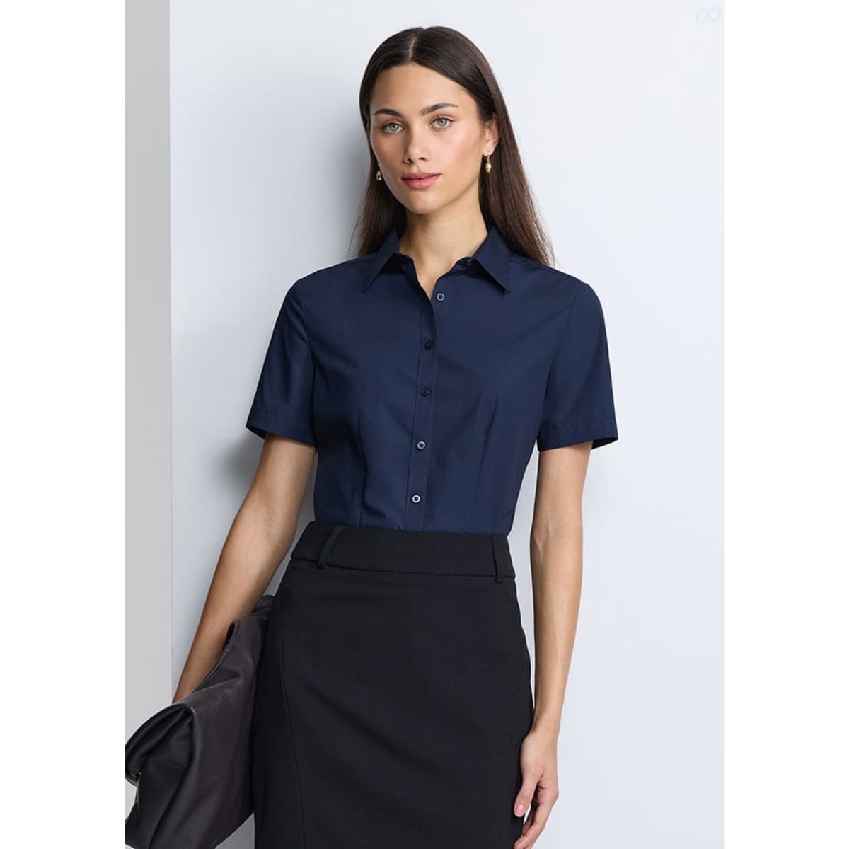 A navy women's short sleeve shirt with a collared neckline and buttons, paired with a black skirt.
