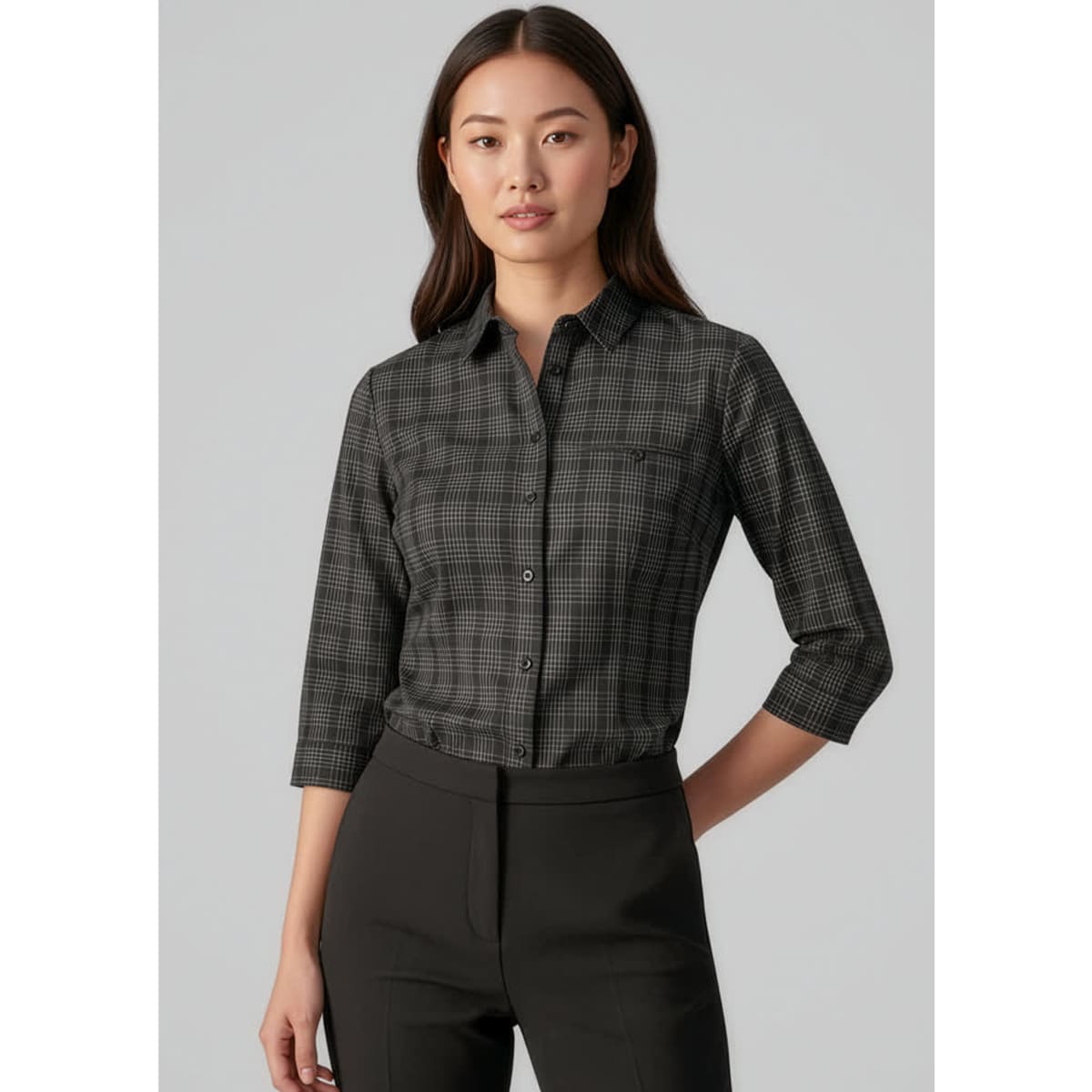 A women's black and white check patterned 3/4 sleeve button-up shirt with a chest pocket. Features a logo.