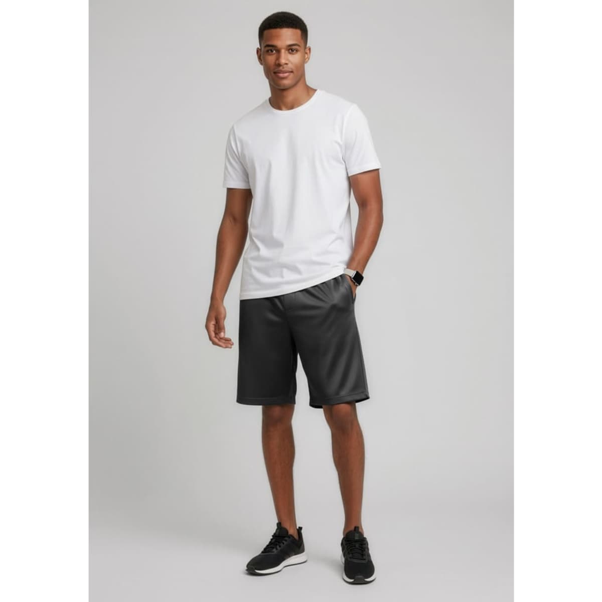 A model wearing black sports shorts and a plain white t-shirt, standing against a neutral background.