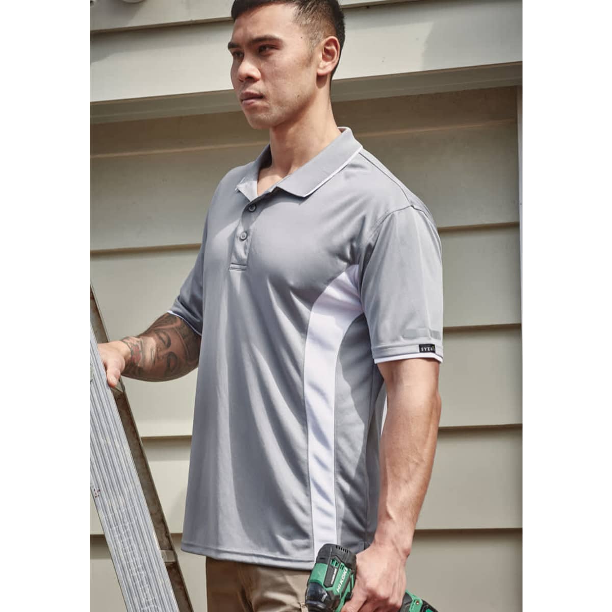 A men's short sleeve polo in grey with white side panels, featuring a logo on the sleeve.