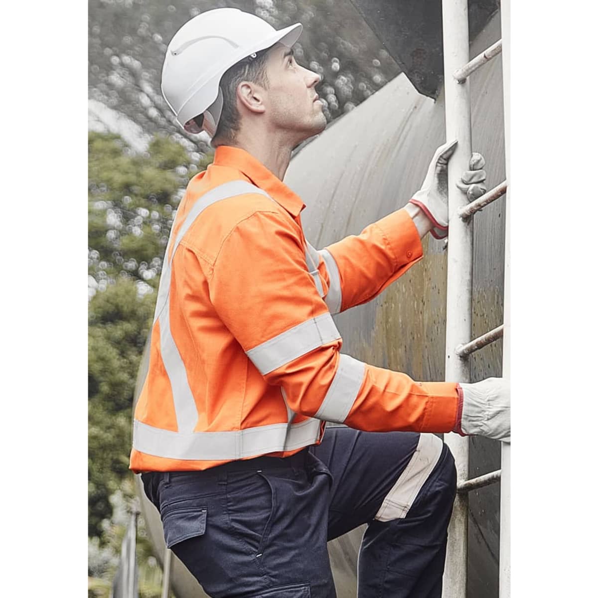 A man wearing an orange flame lightweight shirt with reflective tape climbs a ladder, wearing a helmet and gloves.