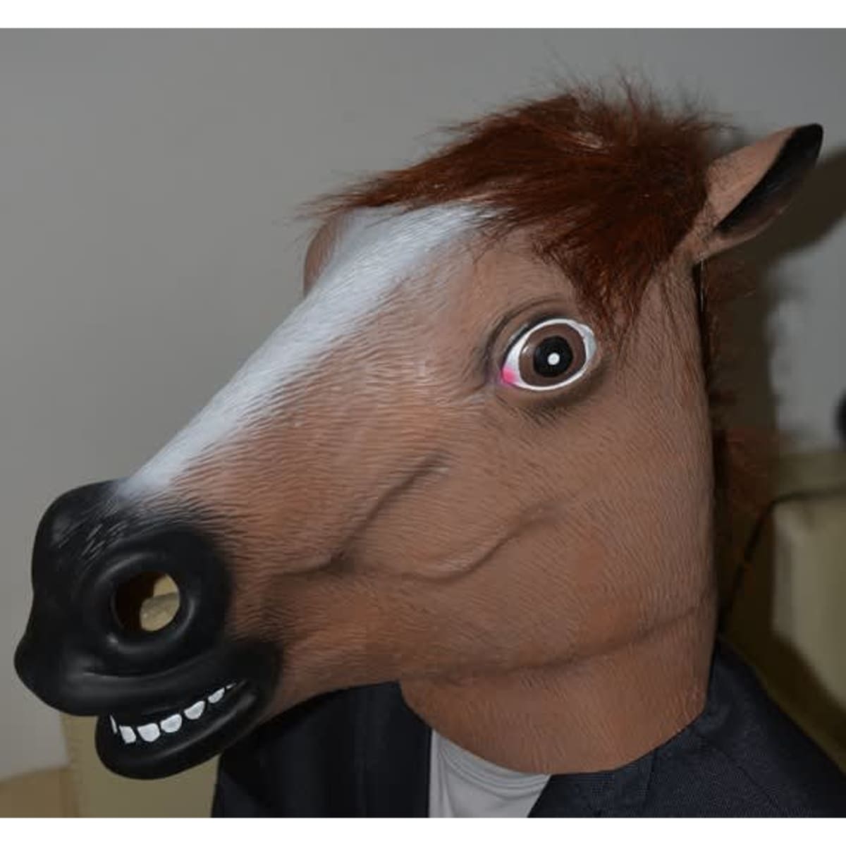 A horse mask with brown fur detail and a large open mouth feature, set against a neutral background.