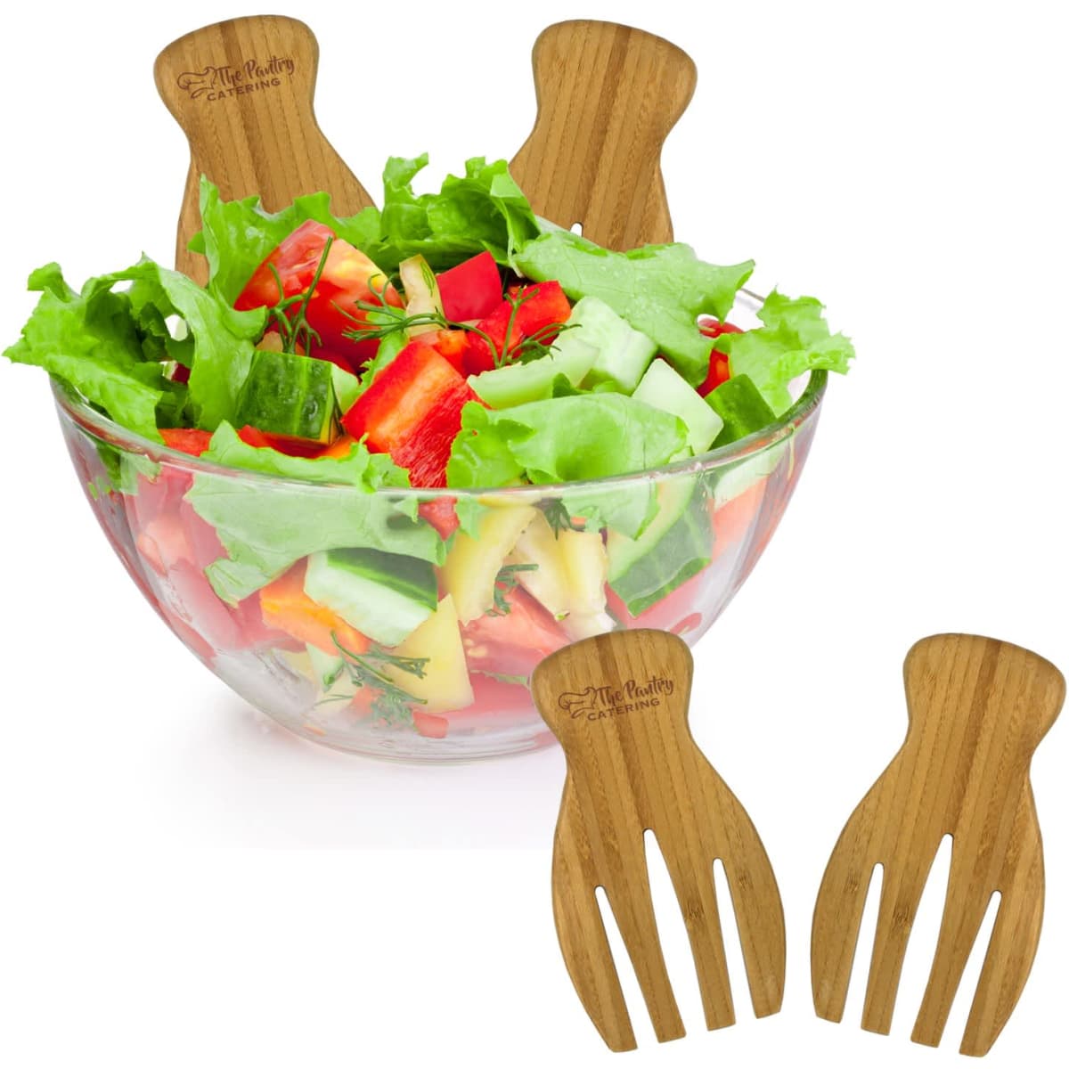 A bamboo salad serving set with two forks placed beside a clear bowl filled with fresh, vibrant salad.