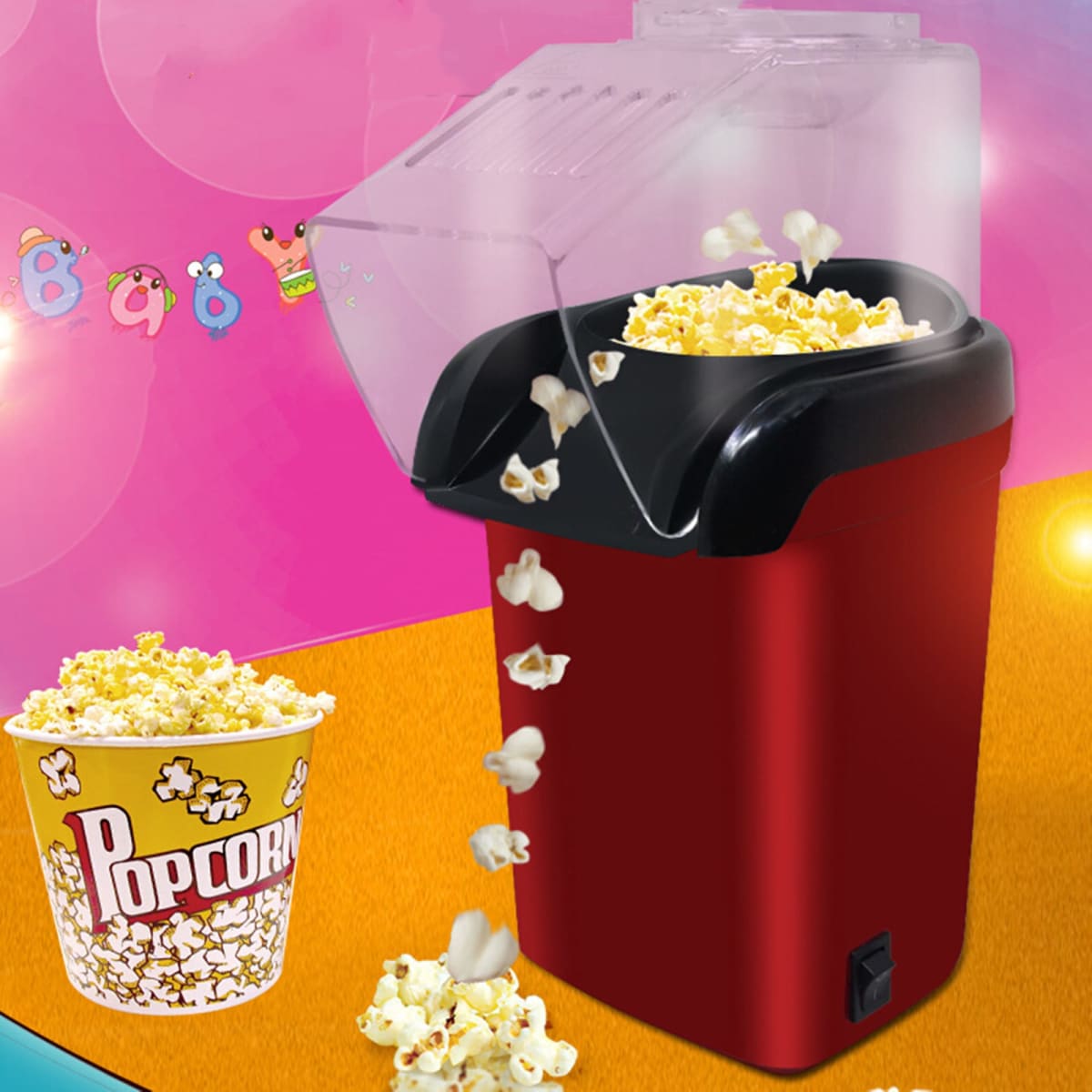 A red home popcorn machine with a clear lid, dispensing popcorn into a yellow cup marked "Popcorn."