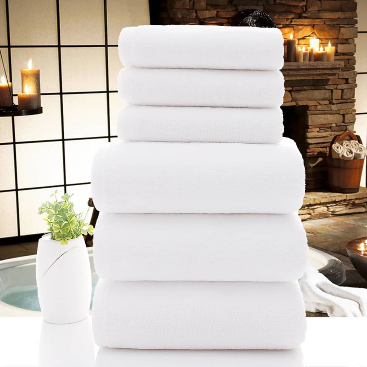 A stack of plush white towels arranged neatly, set against a tranquil spa-like background.