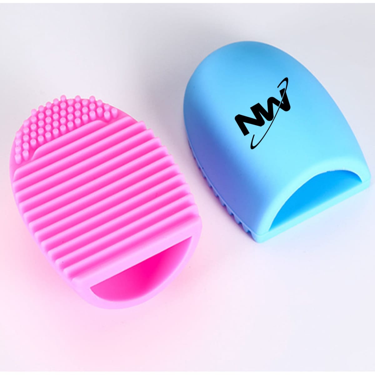 A silicone makeup brush cleaner in pink and blue, featuring text branding on one side and textured surfaces for cleaning.