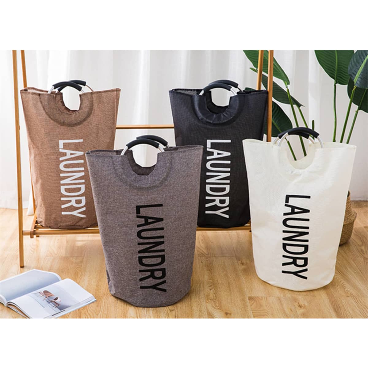Four portable laundry baskets in brown, grey, black, and cream, with a handle and "LAUNDRY" printed on each.