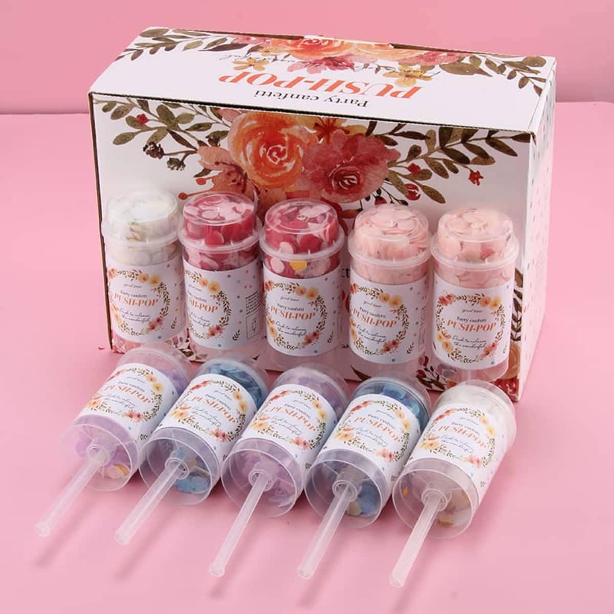 A set of eight Push Pop Confetti containers in various colours, presented in a decorative box with floral designs.