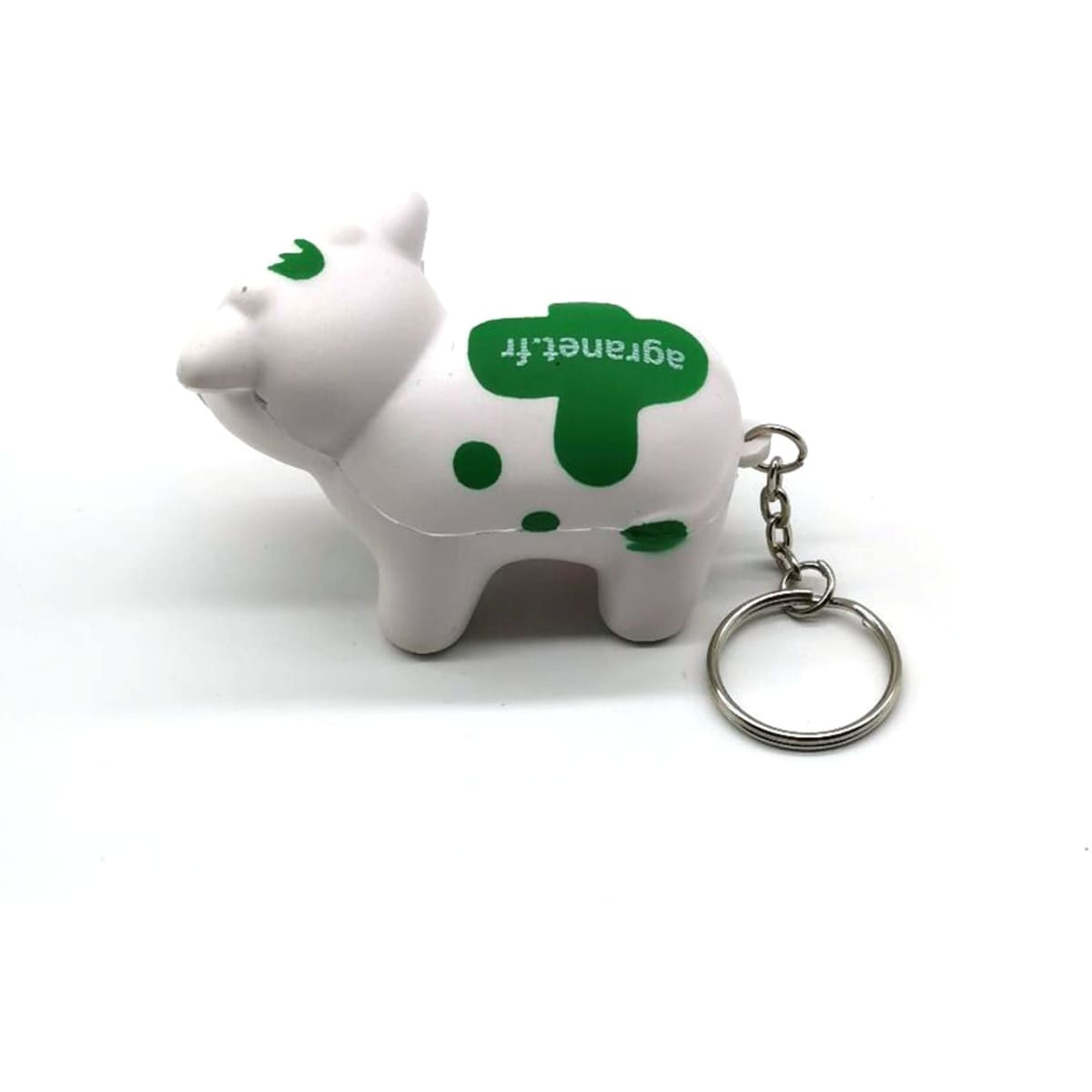 A white and green milk cow stress key chain with a keyring attached.