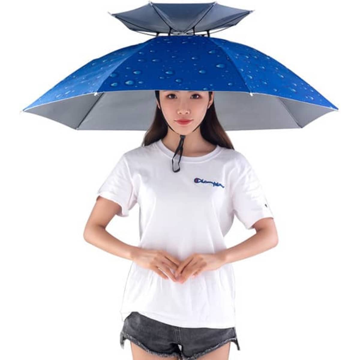 A blue folding sun and rain umbrella cap held by a person wearing a white T-shirt and shorts.