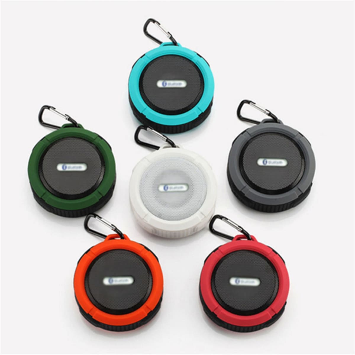 A range of waterproof Bluetooth speakers in black, white, red, green, blue, and orange, each with a carabiner clip.
