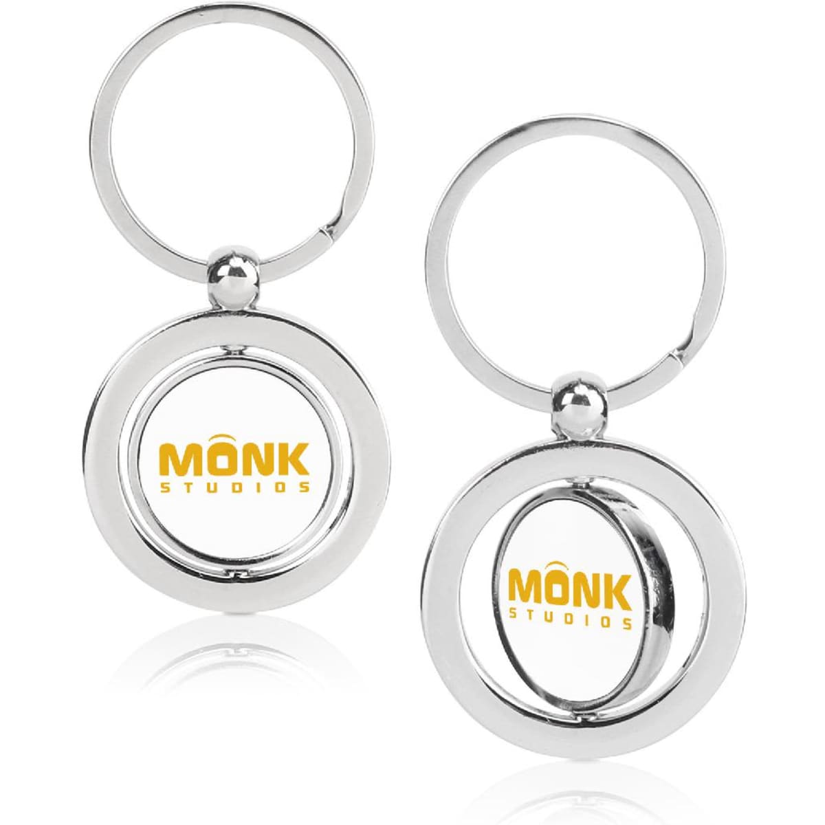 A shiny silver metal keychain featuring a circular design and a logo within.