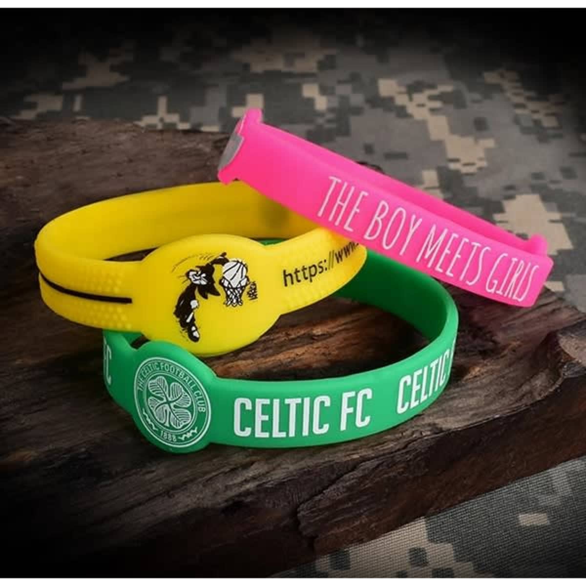 Three rubber wristbands in yellow, pink, and green, featuring different designs and a logo on the green band.