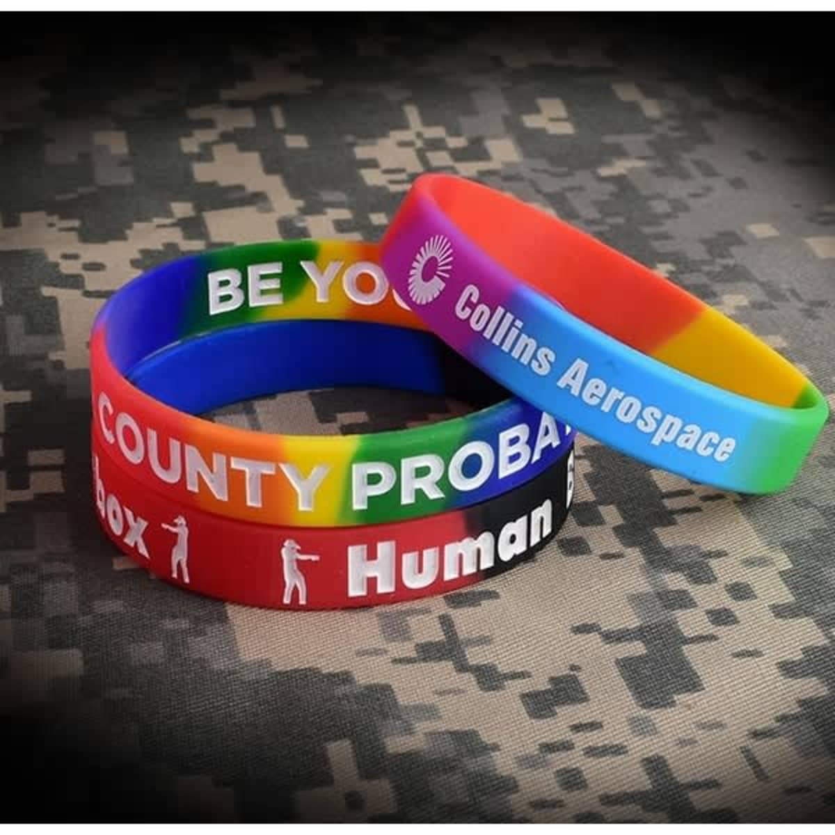 A set of segmented silicone wristbands in various colours, featuring different phrases and a logo.