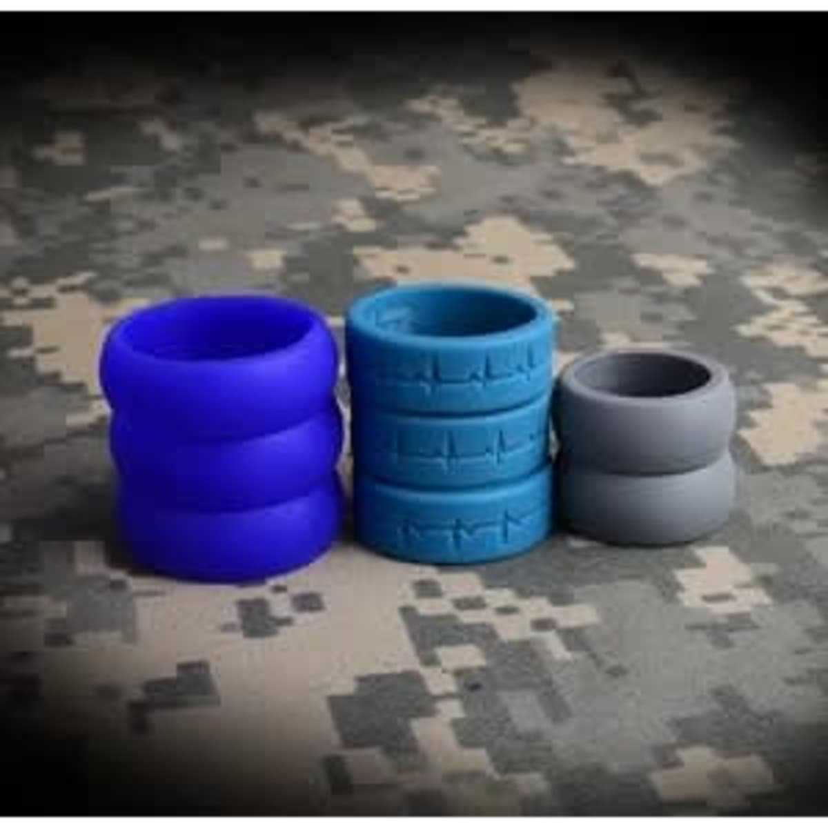 A set of silicone rings in purple, blue, and grey, displayed on a camouflage background.