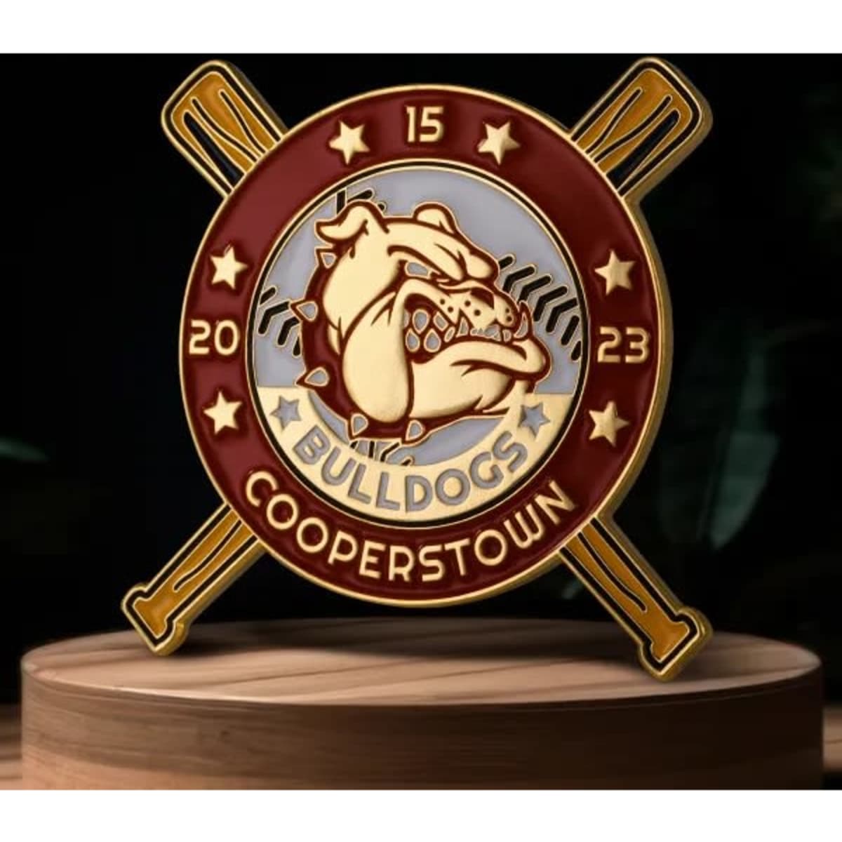 A soft enamel trading pin featuring a bulldog design in maroon, gold, and silver with crossed paddles.