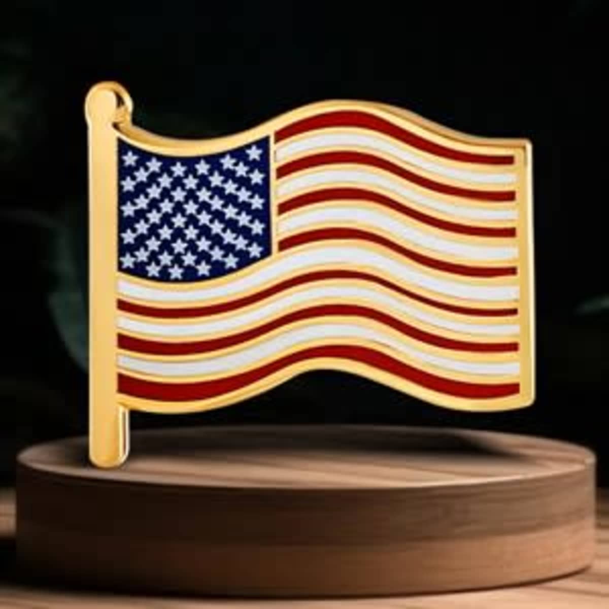 A gold pin shaped like a waving American flag, featuring red and white stripes and a blue field with white stars.