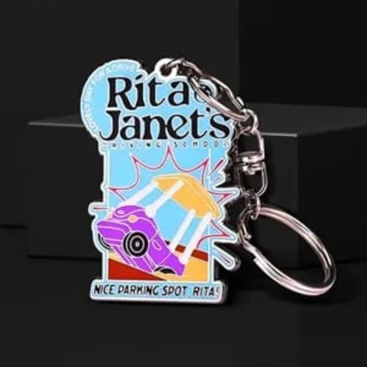 A hard enamel keychain featuring a purple car design with a keyring, showcasing vibrant colours and a logo.