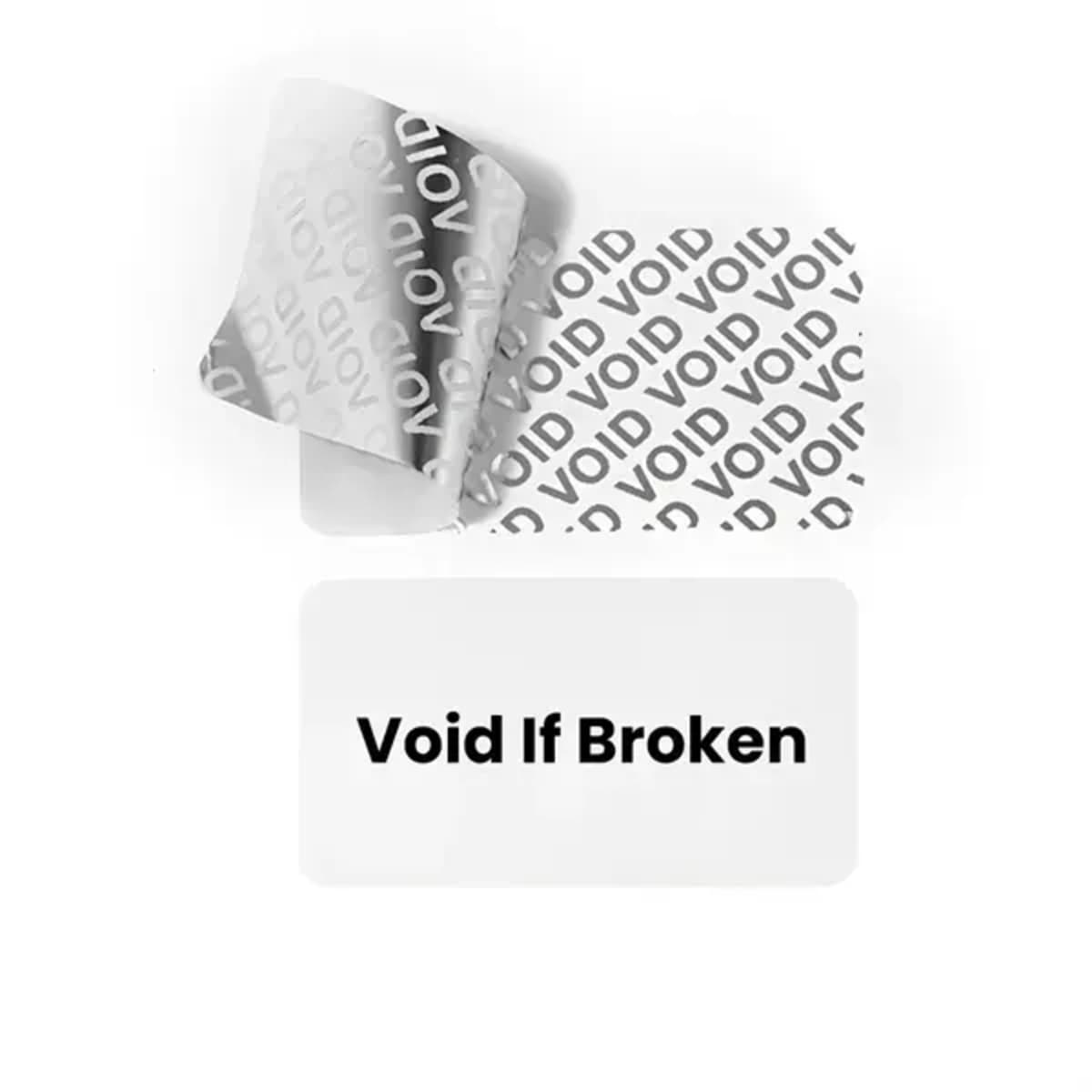 A stack of tamper-evident labels in silver and white with a repeated "VOID" pattern and a clear label stating "Void If Broken."