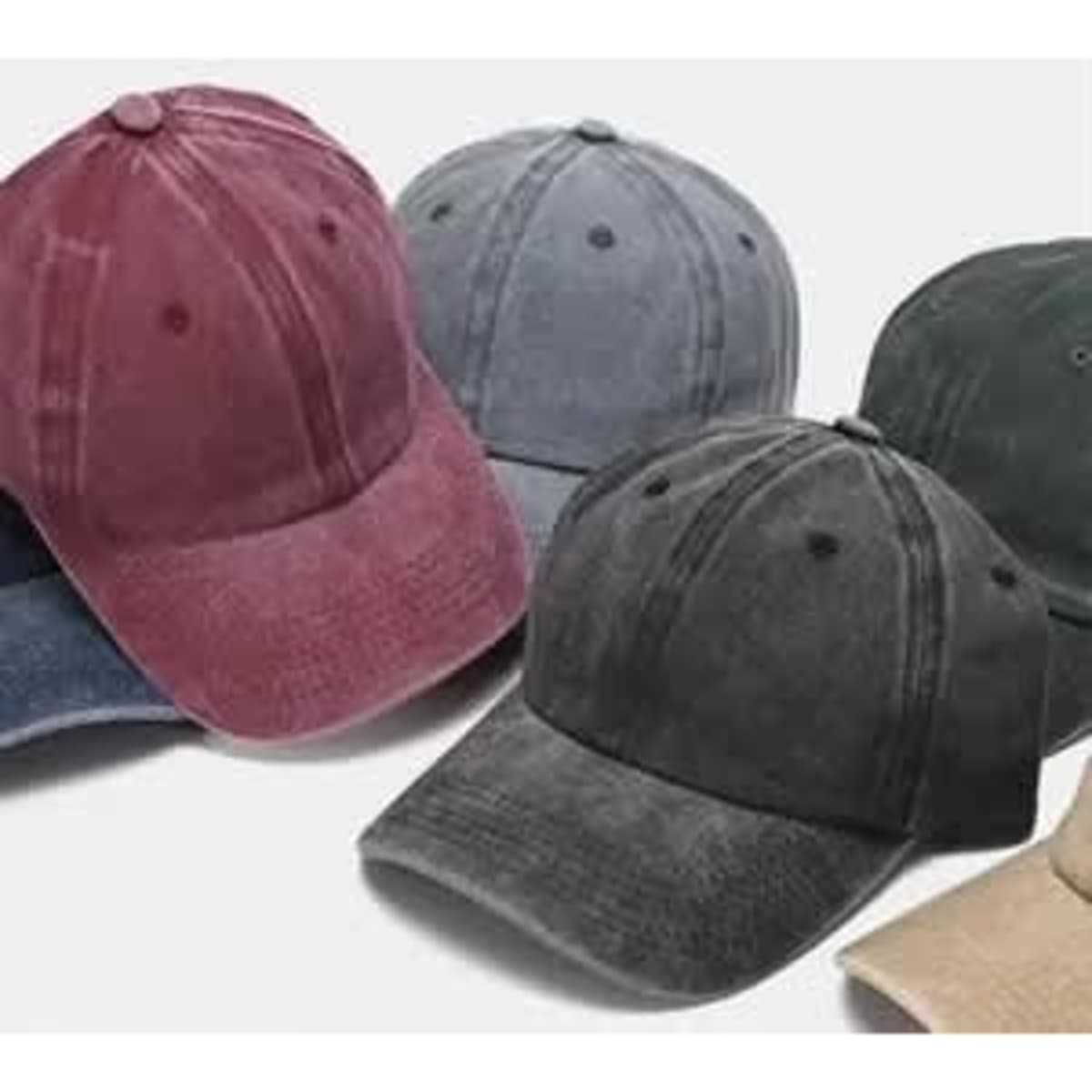 Vintage washed custom dad hats in various colours, including burgundy, grey, dark green, and beige, with logos.