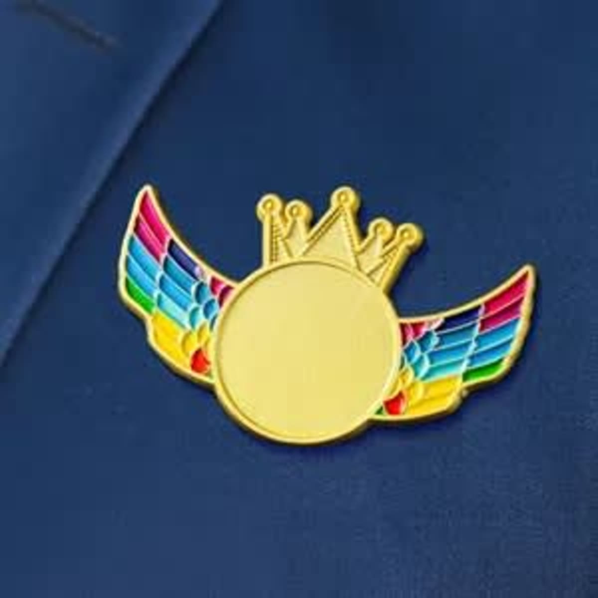 A custom crown wing name badge with a gold finish and colourful wing designs, displayed against a blue background.