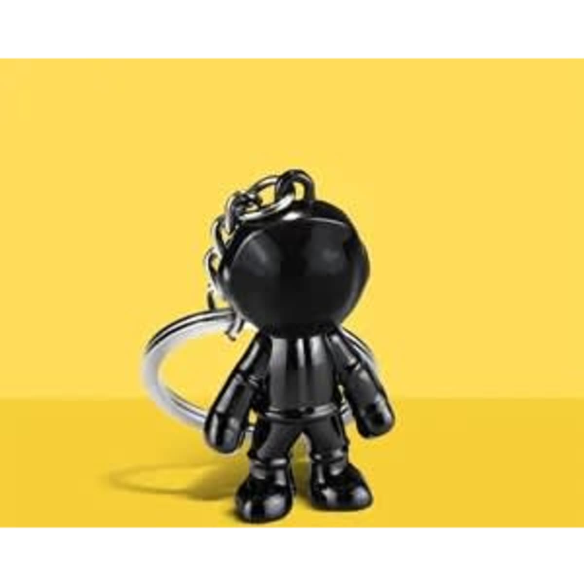 A black metal 3D astronaut key chain pendant featuring a small astronaut figure with a keyring attached.
