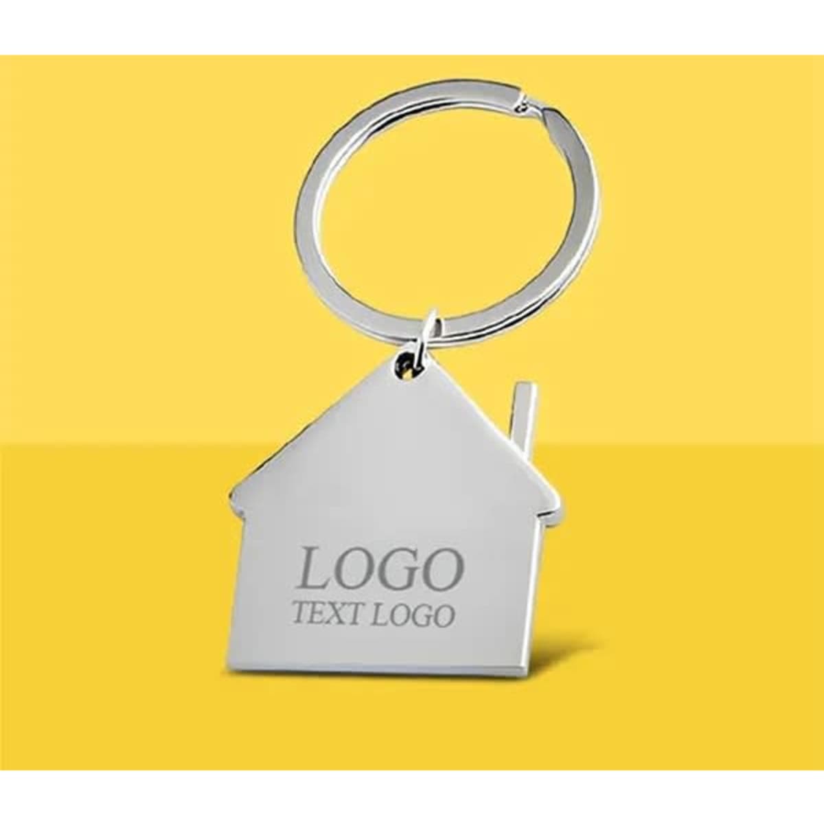 A metal key tag in the shape of a house, silver in colour, with a keyring attachment and a logo displayed.