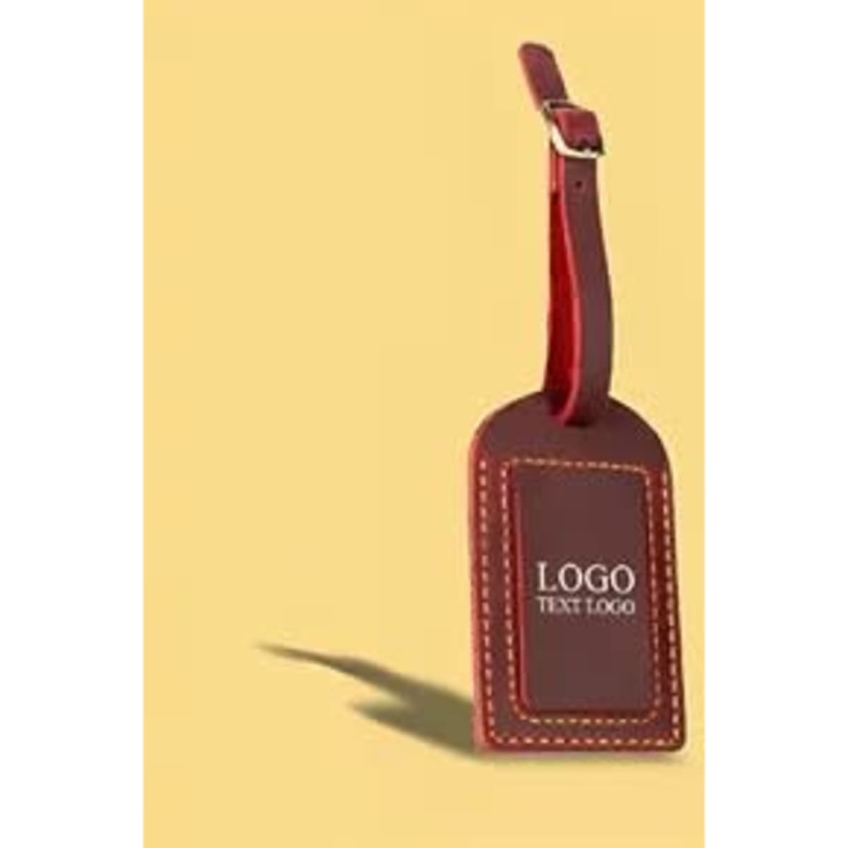 A vintage crazy horse leather luggage tag in brown with orange stitching, featuring a logo design.