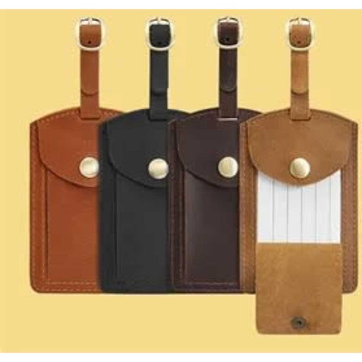 A set of four flap leather travel luggage tags in brown, black, dark brown, and tan, each featuring a snap closure.