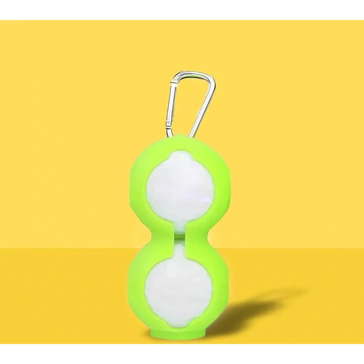 A green silicone golf ball holder featuring a carabiner, designed to securely hold two golf balls.