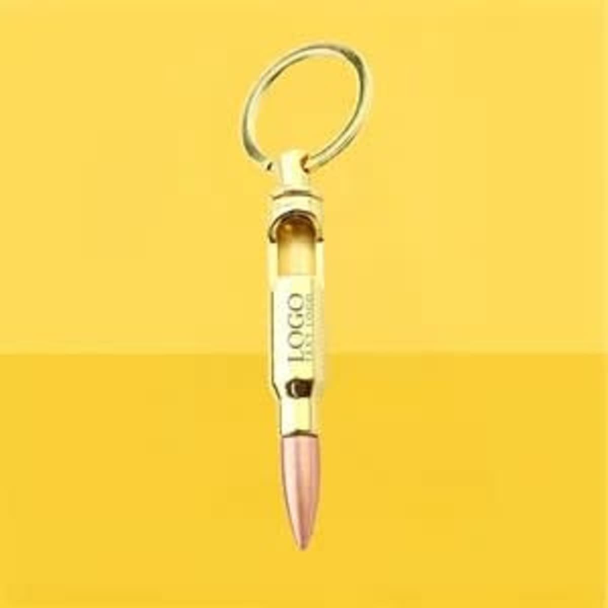 A drink bottle opener keychain in gold and pink, featuring a logo, attached to a metal ring.