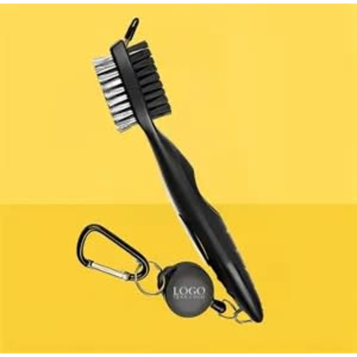 A black golf club brush and groove cleaner with a carabiner attachment, set against a yellow background.