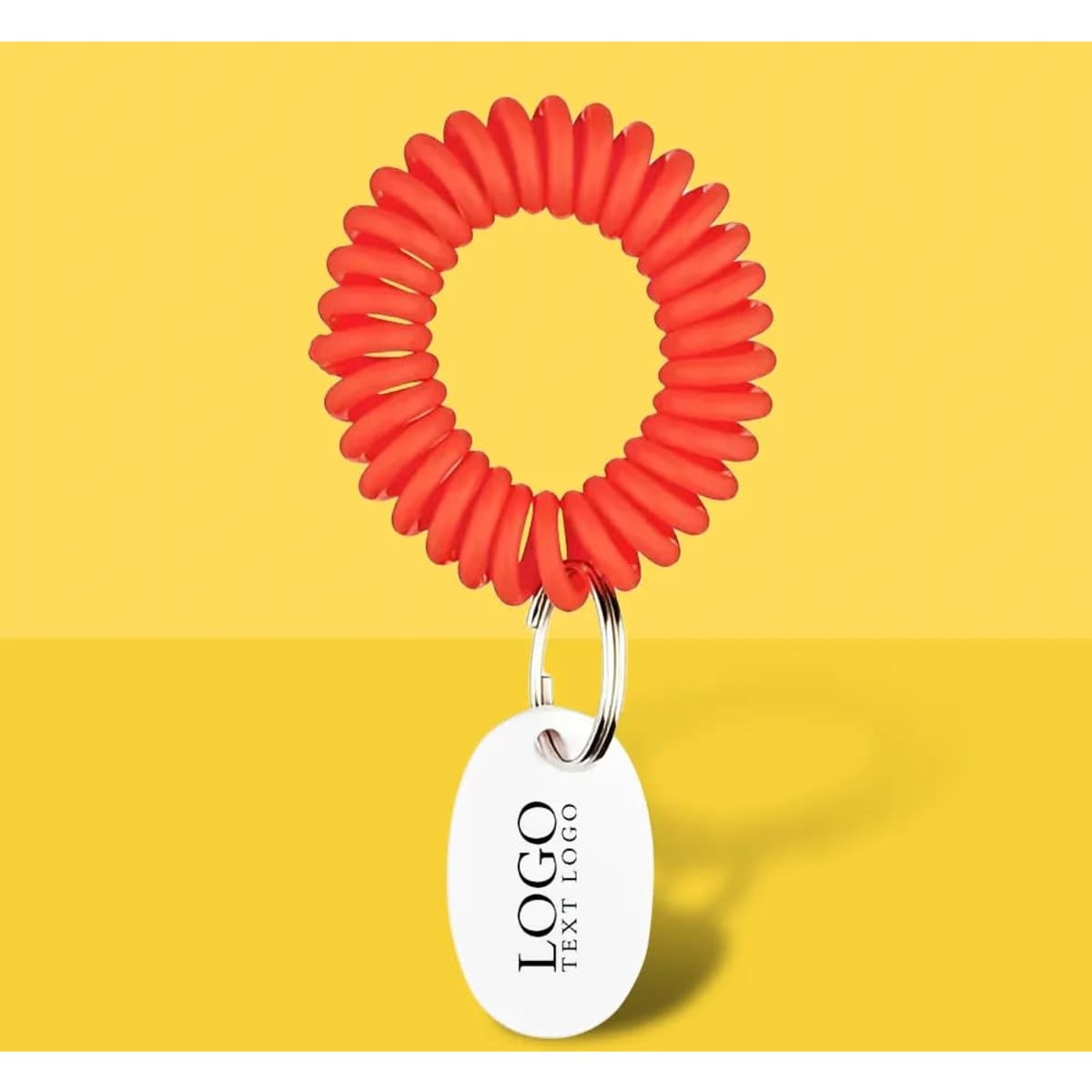 A red EVA bracelet wrist coil with a keyring tag, featuring a logo, against a yellow background.