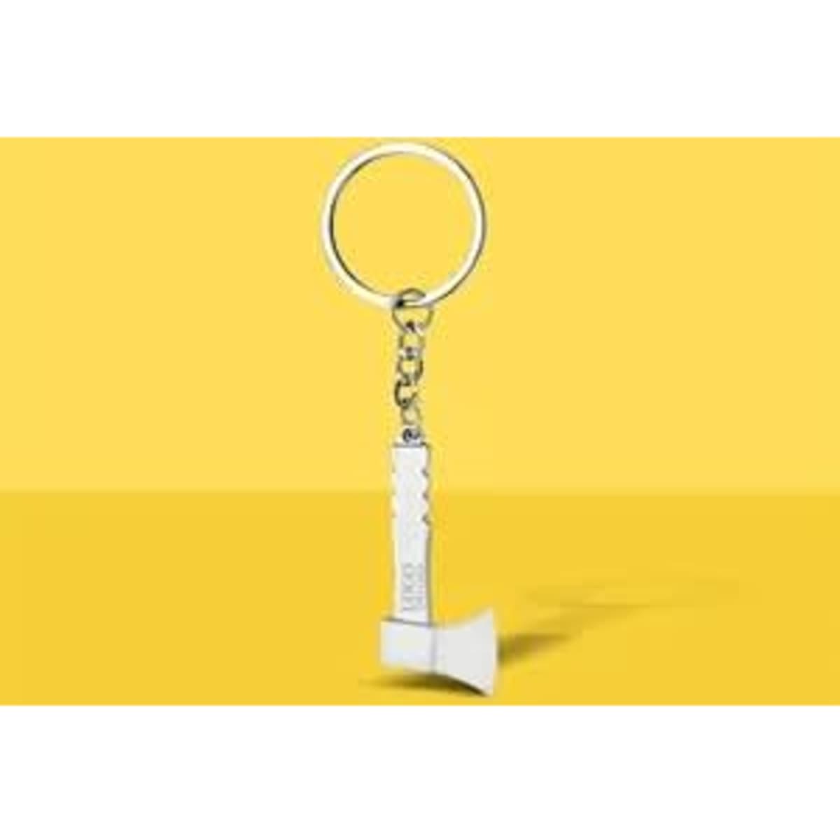 A mini axe keychain in silver with a keyring, displayed against a bright yellow background.