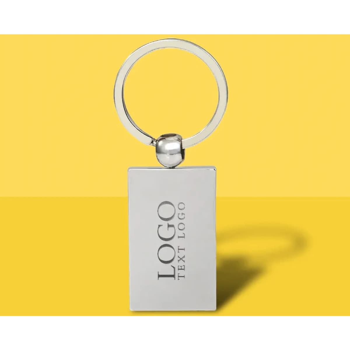 A flat metal keychain in silver, featuring a rectangular shape and a ring attachment. It includes a logo.