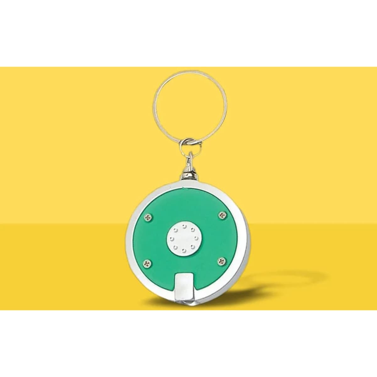 A round LED keychain with a green front and silver edges, featuring a keyring attachment.