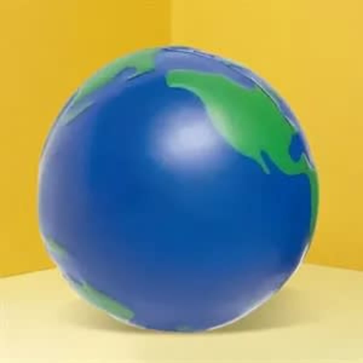 A spherical stress ball designed to resemble Earth, featuring blue and green colours on a yellow background.