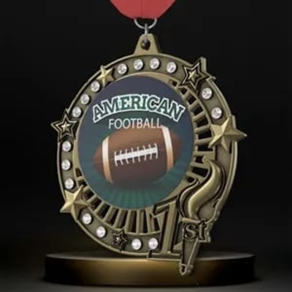 A gold medal with a red ribbon, featuring a football design and decorative stars, along with a logo.