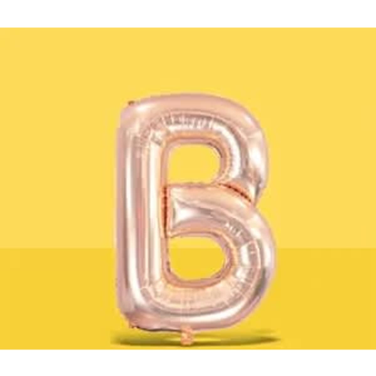 A rose gold letter "B" balloon on a bright yellow background, featuring a shiny finish.