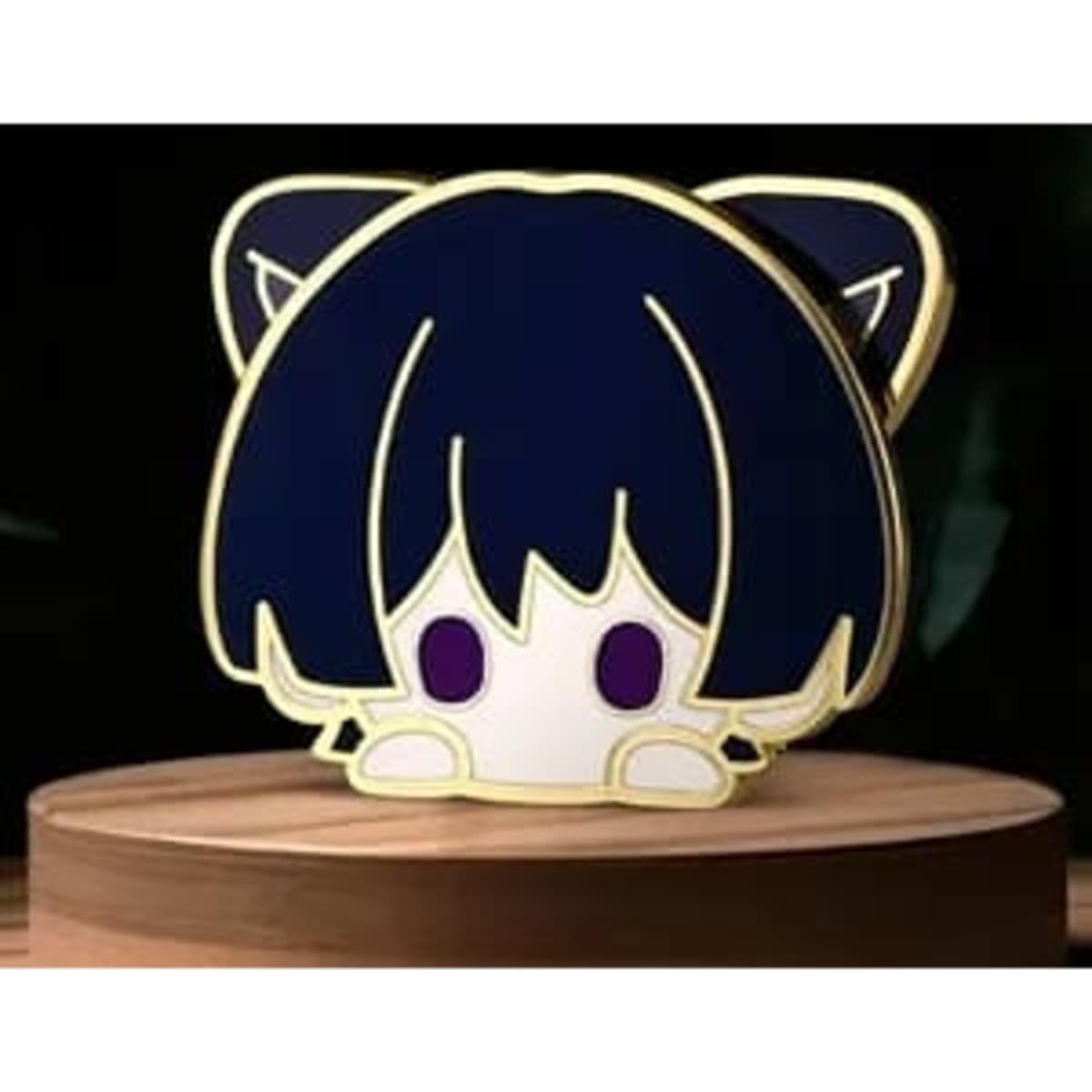 A layered pin featuring a character with dark blue hair and cat ears, displayed on a wooden pedestal.
