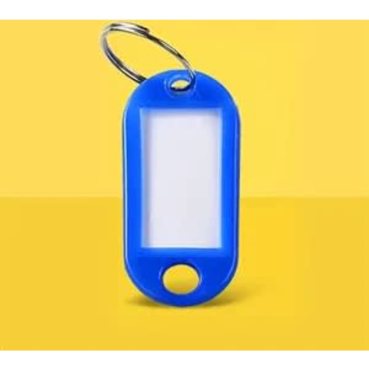 A blue plastic key tag with a label window, attached to a metal ring against a yellow background.
