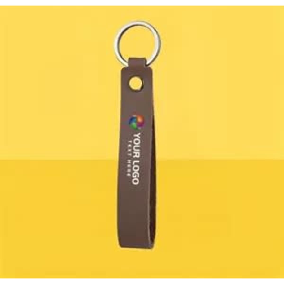 A brown premium leather key chain with a silver ring and a logo. Set against a yellow background.
